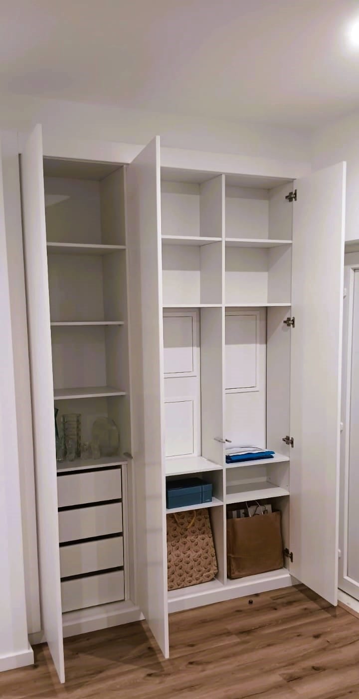 Inside a fitted wardrobe, with shelves, drawers and hanging space