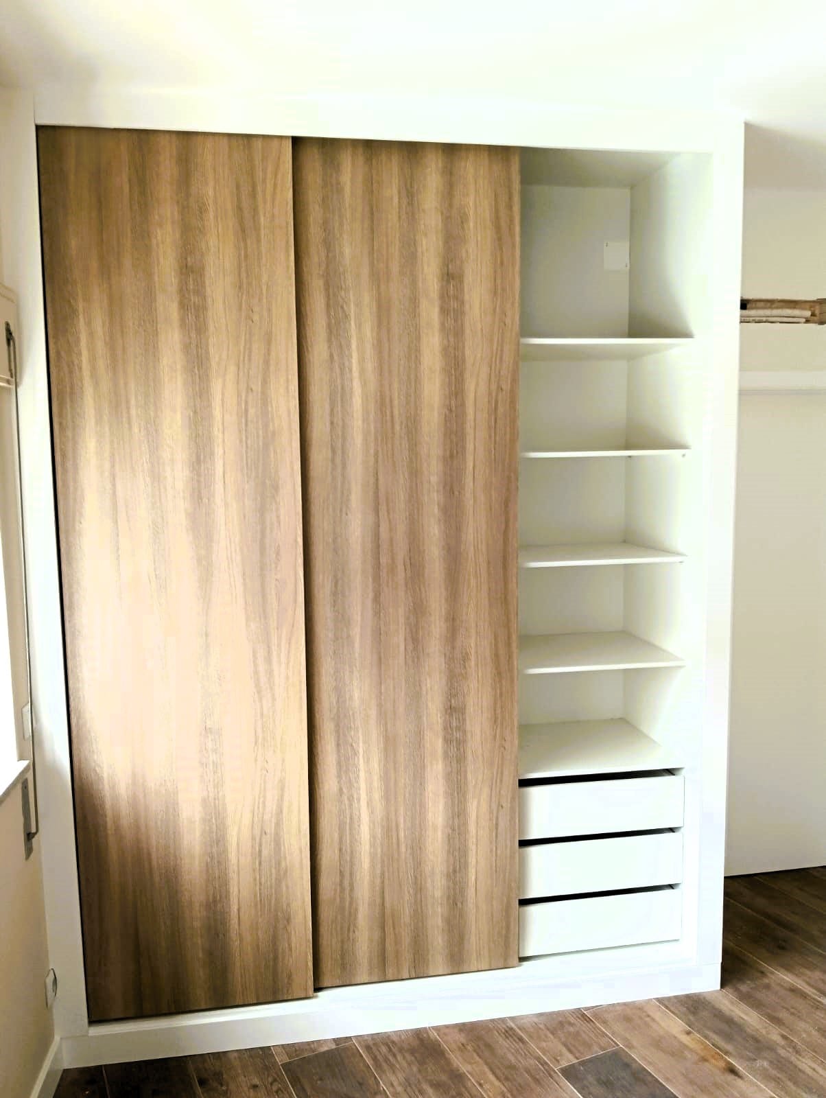 Sliding-door wardrobe in light wood, with shelves and drawers on show